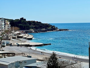 A coastal area with a beach, promenade, and buildings.