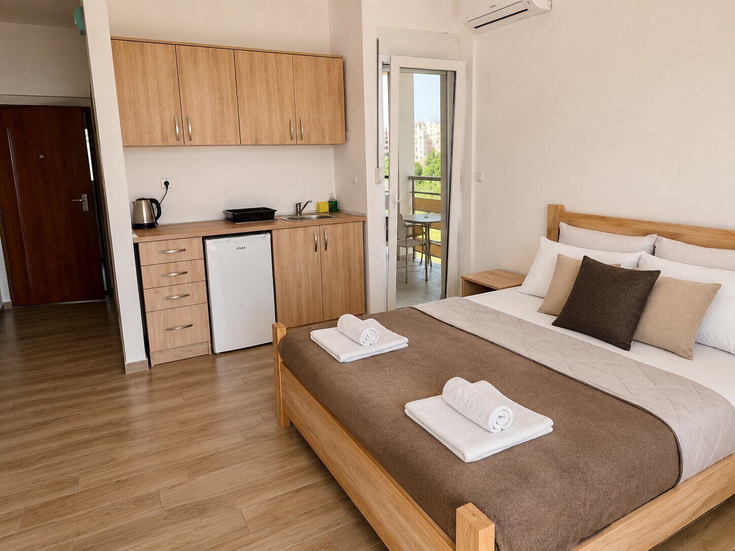 A bedroom with a bed, bedside table, and a view of the outside.
