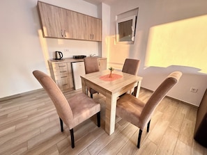 Una cocina moderna con armarios de madera, una mesa de comedor con cuatro sillas y un ventanal.