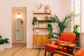 Una habitación acogedora con un aparador de madera, un globo terráqueo y una silla roja.