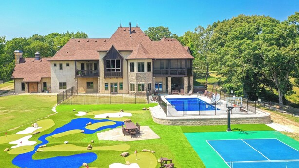 Ein großes Haus mit Swimmingpool, Tennisplatz und Minigolfanlage.