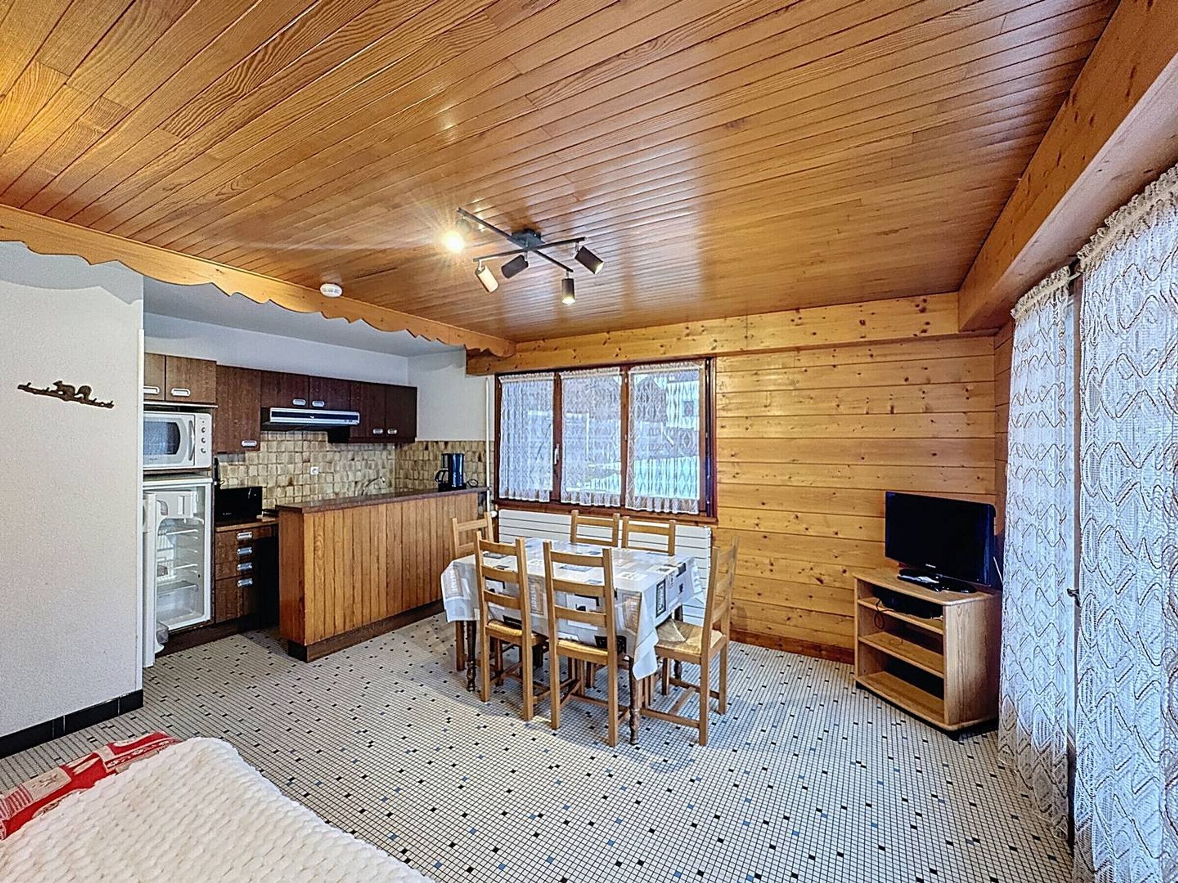 A cozy cabin with a kitchen, dining area, and a TV.