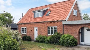 A two-story brick house with a red-tiled roof, a small attic window, and a front door. - 4 Star Holiday Home in Vaeggerlose (Vaeggerlose)