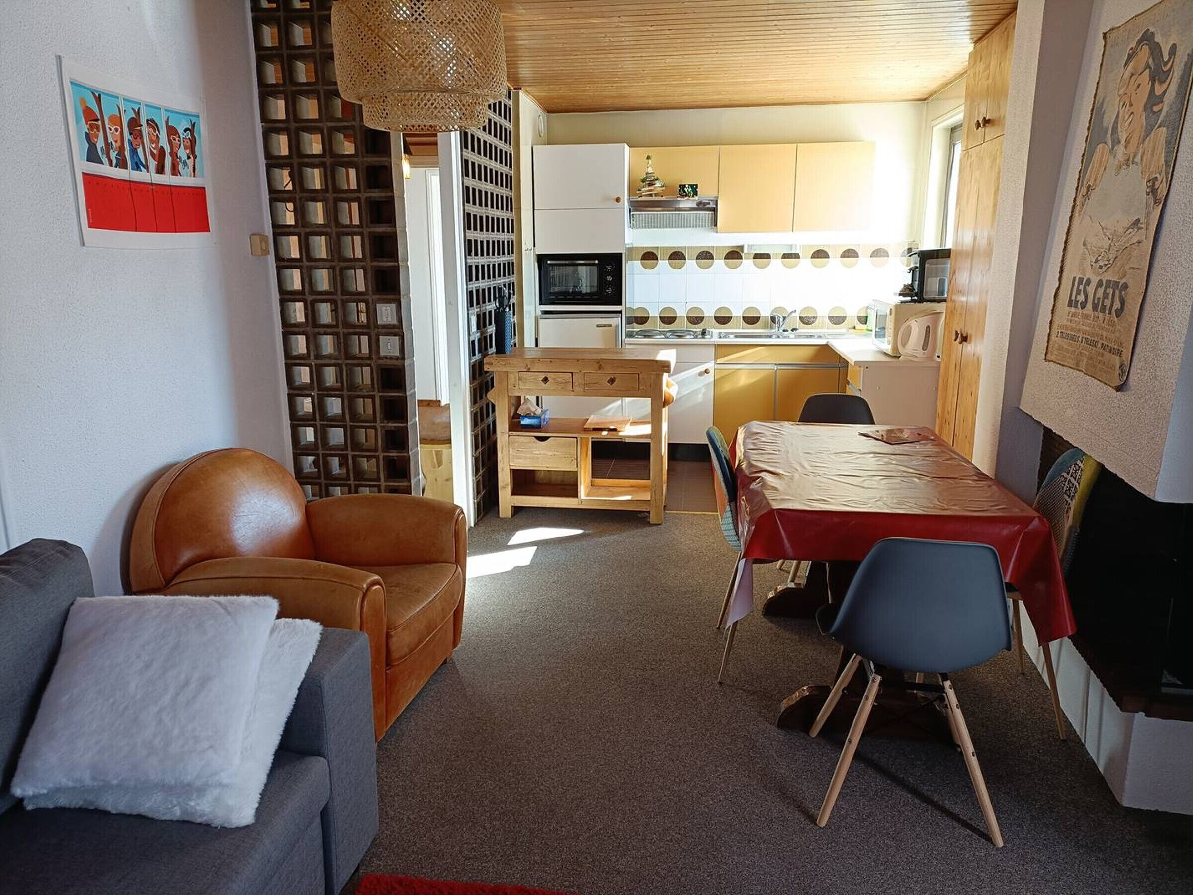 A compact living space with a sofa, a dining table, and a kitchen area.