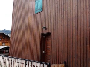 A wooden building with a door and a window.