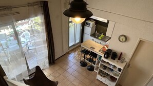 A compact living space with a kitchenette, a dining area, and a view of the outside.