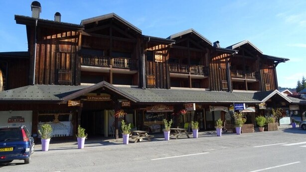A wooden building with multiple balconies and a sign that reads "Le Plaza du Soleil". - Spacious Studio Duplex in Les Gets - Sleeps 6, Garage, Near Slopes and Shops (Les Gets)