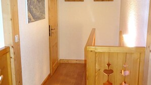 Une pièce avec une porte en bois, une petite fenêtre et une rambarde en bois.