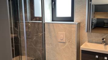 Deluxe Cabin | Bathroom | Shower, heated floors, towels, soap