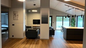 Ein modernes Interieur mit Holzboden, einer Couch, einem Schreibtisch und einem Fernseher.