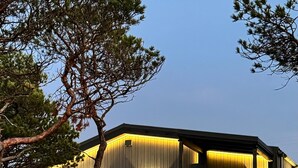 Ein modernes Haus mit Satteldach, großen Fenstern und einer gut beleuchteten Außenansicht.