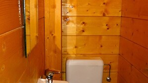 A small, wooden-paneled bathroom with a white sink and toilet. - Les Gets - Duplex 5 rooms, 10 pers, near slopes, terrace, parking (Les Gets)