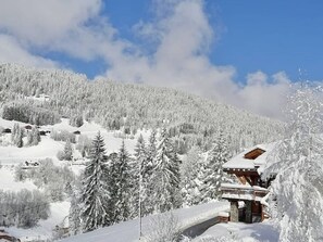 A snow-covered mountain with a wooden chalet and several cabins.
