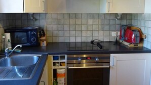 A kitchen with a microwave, toaster, coffee maker, and oven. - Les Gets Duplex 3-Room - 6 Pax, Comfortable, Garage (Les Gets)