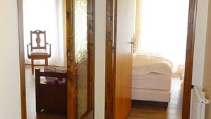 Un dormitorio con cama, una silla y un radiador.
