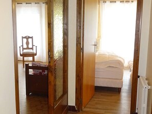 A bedroom with a bed, a chair, and a radiator.