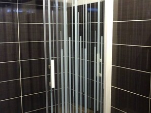 A modern bathroom with dark tiles and a vertical glass partition. - Modern 3-Room Apartment, 5 People, Garage, Near Slopes, WiFi (Les Gets)