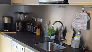 Une cuisine moderne équipée d’appareils électroménagers en acier inoxydable, d’un évier et d’un four à micro-ondes.