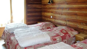 A cabin room with two beds, wooden walls, a window, and a wall-mounted lamp. - Spacious 2-BR Apartment for 7 with WiFi, Central Heating, and Parking - Les Gets (Les Gets)
