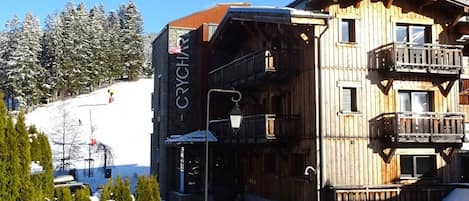 A wooden building with balconies, a sign reading "CRYCHART", and a snowy landscape in the background.