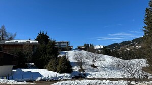 A snow-covered landscape with buildings, trees, and a clear blue sky. - Spacious 6-Room Duplex, 12 Guests, WiFi, Garage, Close to Slopes - Sheets & Towels Included in Winter (Les Gets)