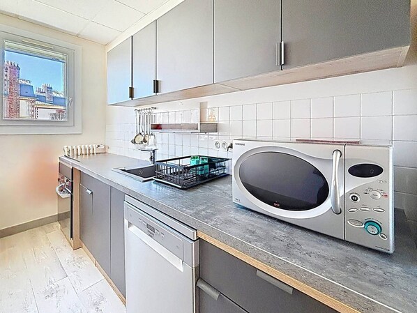 A modern kitchen with a dishwasher, a microwave, and a dish rack. - Comfortable apartment near Port Guillaume for 4 with pets allowed (Dives-sur-Mer)