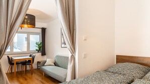 Une chambre à coucher avec un lit, un canapé, une table et une fenêtre.