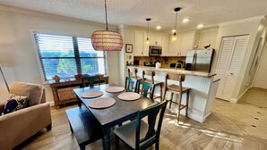 A modern kitchen with white cabinets, a central island, and pendant lighting. - FREE DAILY FUN with this beach lovers dream getaway! (Saint Augustine)
