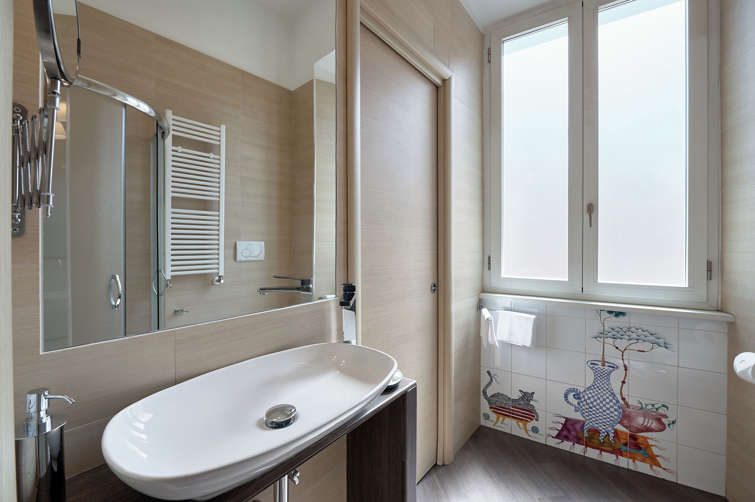 Un baño moderno con un lavamanos grande blanco, un espejo, un perchero y una ventana con vistas.