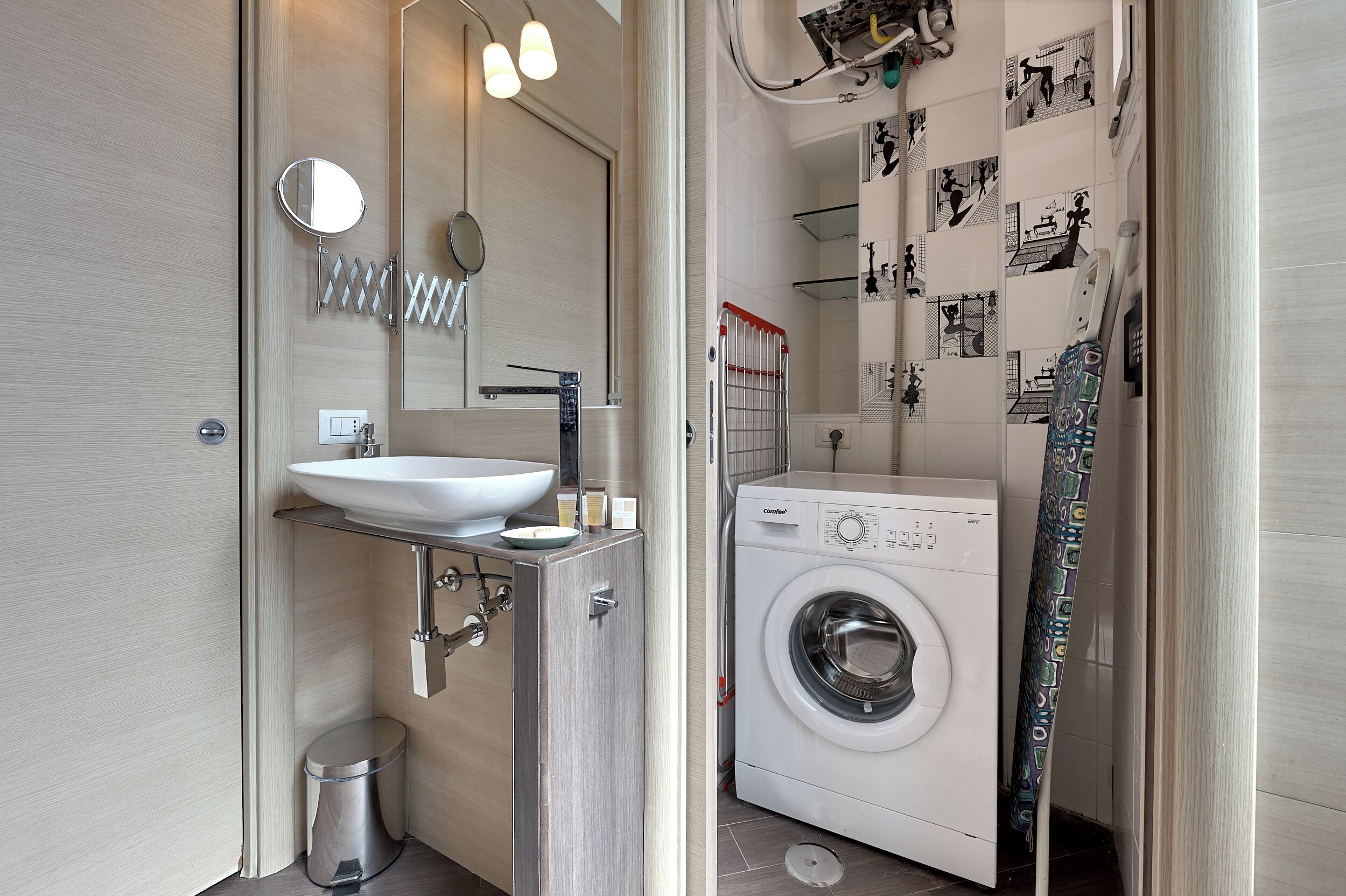A modern bathroom with a sink, mirror, and a washing machine.