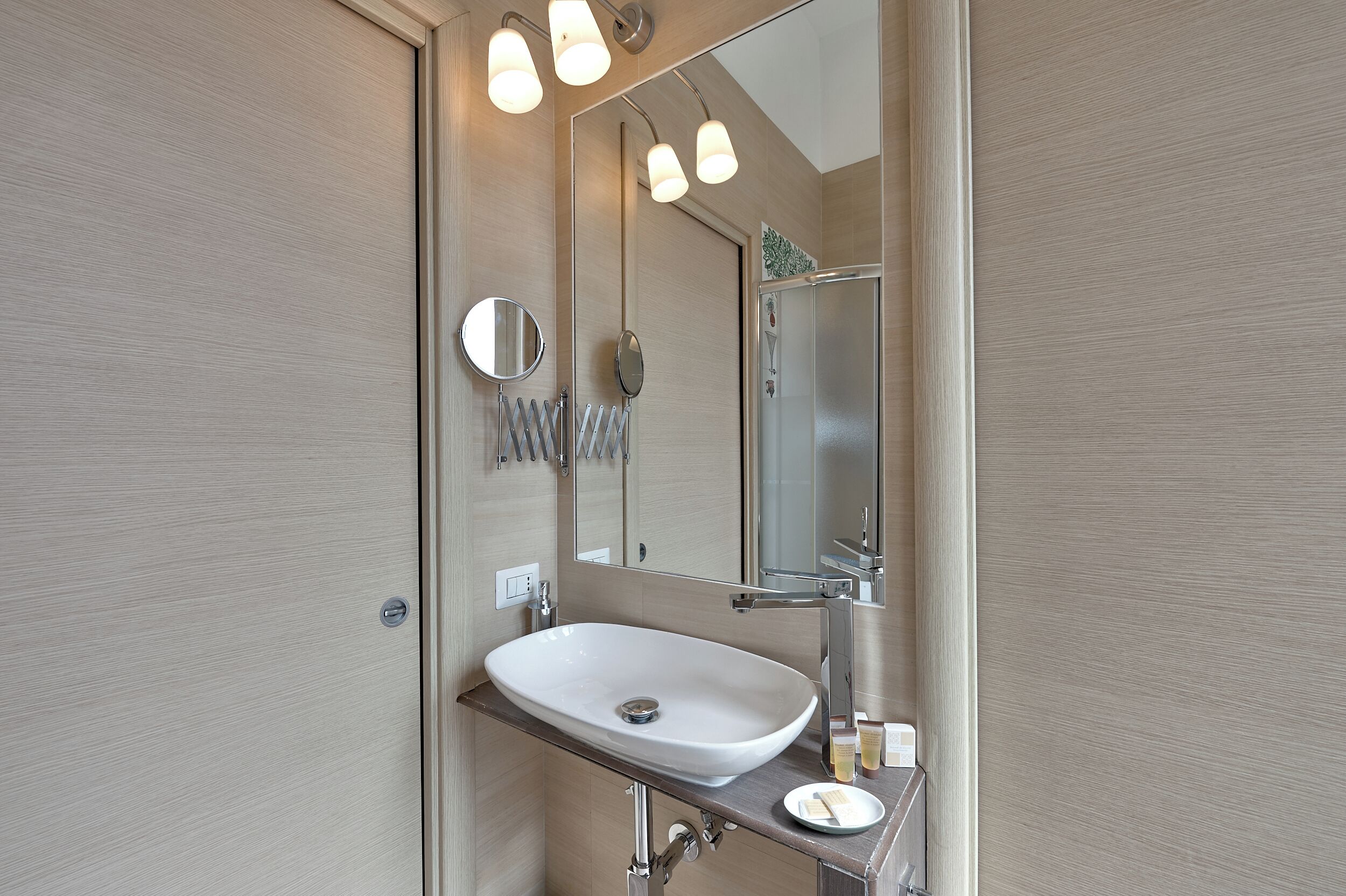 Un bagno moderno con uno specchio grande, un lavandino bianco e un porta asciugamani.