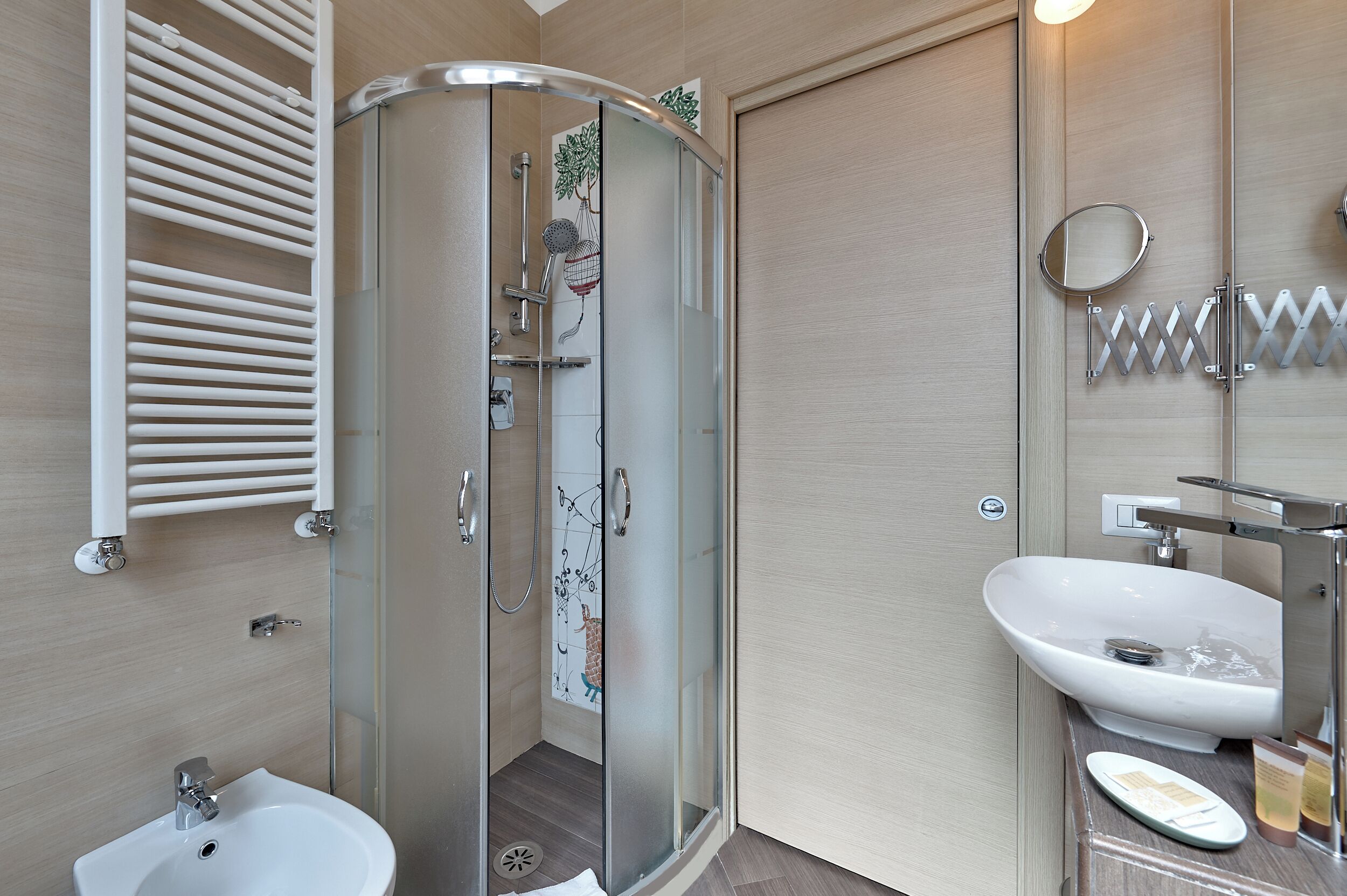 A modern bathroom with a glass-enclosed shower, a sink, and a toilet.