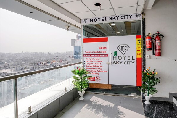 A hotel entrance with a balcony overlooking a cityscape.