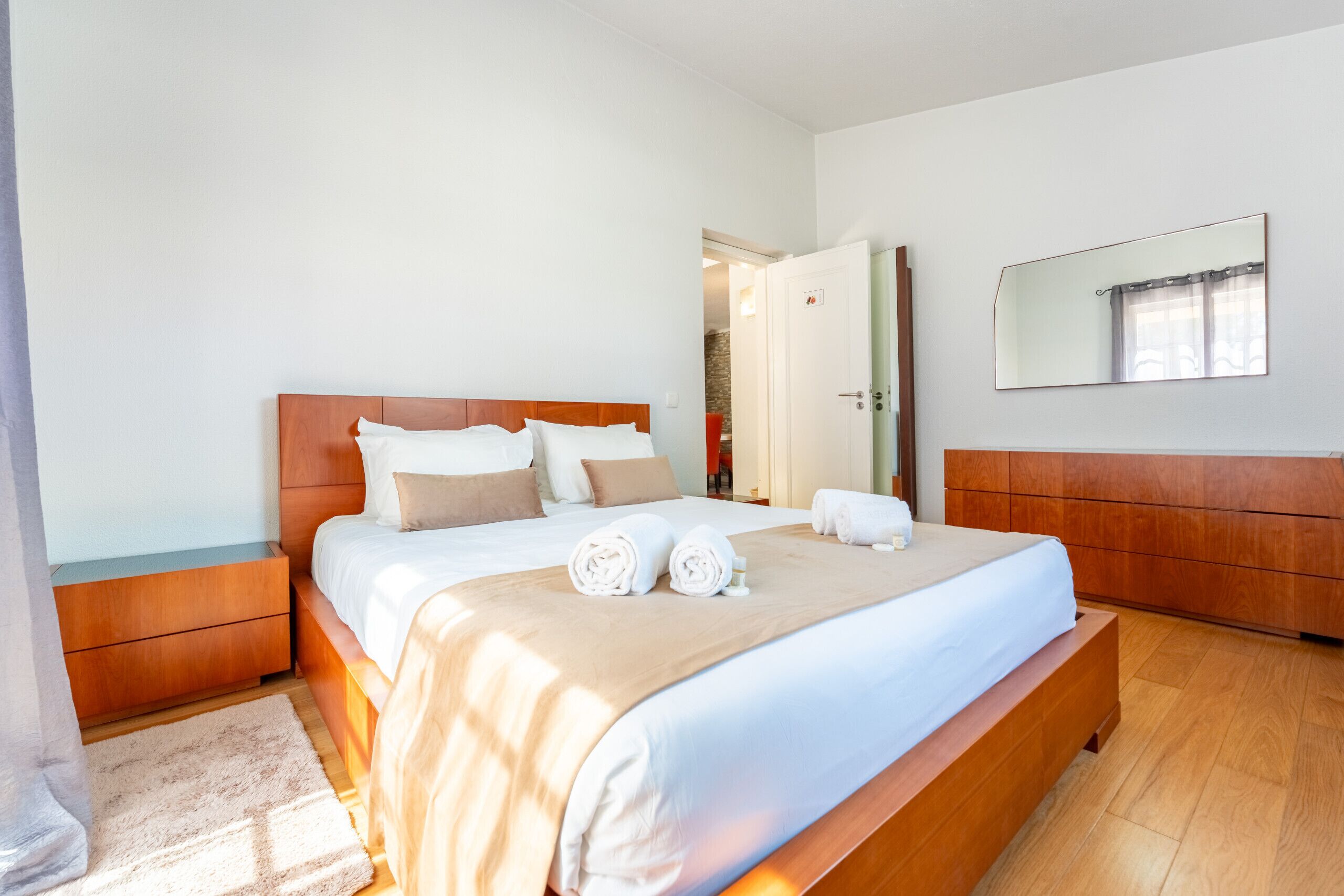 Un'ampia camera da letto con un letto grande, una testiera in legno e un armadio a muro.