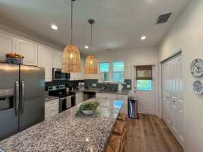 A modern kitchen with granite countertops, stainless steel appliances, and a central island.