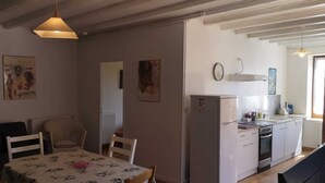 Un espai habitable compacte amb zona de menjador, cuina i un petit seient.