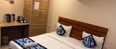 A hotel room with a bed, bedside table, and a wardrobe.