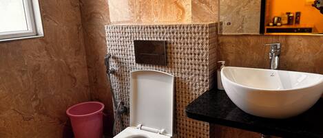 Een badkamer met toilet, wastafel en douche.