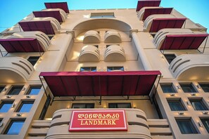 A hotel facade with a prominent landmark sign, multiple balconies, and a symmetrical architectural design. - Landmark Hotel (Batumi)