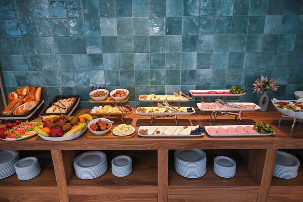 A buffet table with various food items and plates. - Landmark Hotel (Batumi)