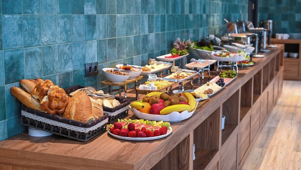 A buffet with various food items including bread, fruits, and vegetables. - Landmark Hotel (Batumi)