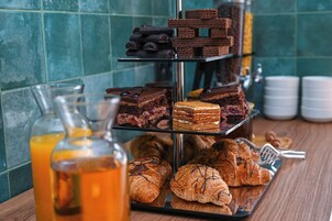 Una exhibición de postres con diferentes pasteles y tartas en un soporte escalonado.