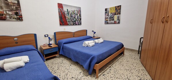 A hotel room with two beds, a wooden wardrobe, and artwork on the walls. - MONDELLO VIEW WHITE HOUSE (Palermo)