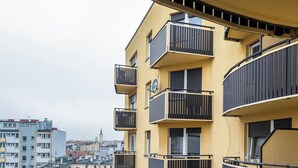 Un immeuble à plusieurs étages, doté de balcons et offrant une vue sur le paysage urbain environnant.