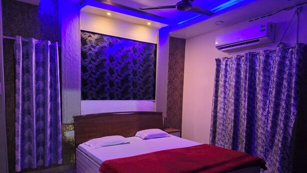 Een slaapkamer met een bed, gordijnen, een plafondventilator en een airconditioning.