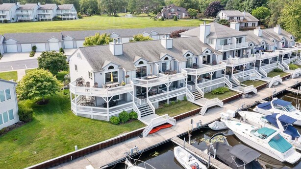 A waterfront property with multiple houses, a dock, and boats. - Sunset Landing: Waterfront Luxury Condo with High End Finishes Throughout (Douglas)