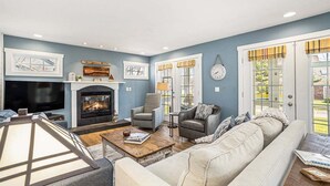 Un salon avec une cheminée, un canapé, une table basse et un téléviseur.