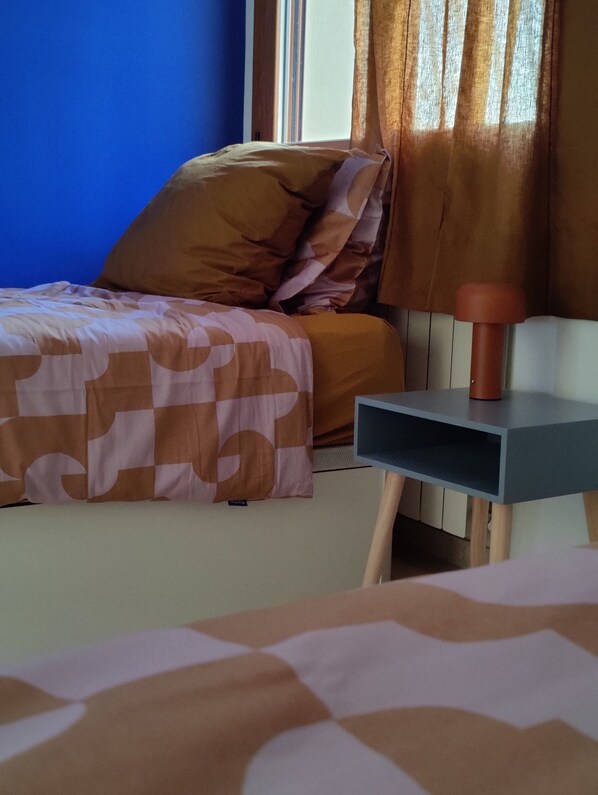 A bedroom with a bed, a nightstand, and a lamp.