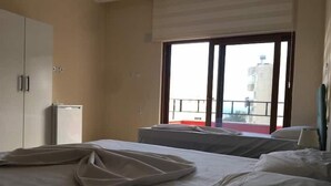 A hotel room with a bed, a wardrobe, a small table, and a window with a view of the outside. - Anamur Çilek Otel (Anamur)