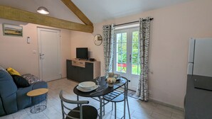 Un espacio habitable compacto con kitchenette, comedor y sofá.
